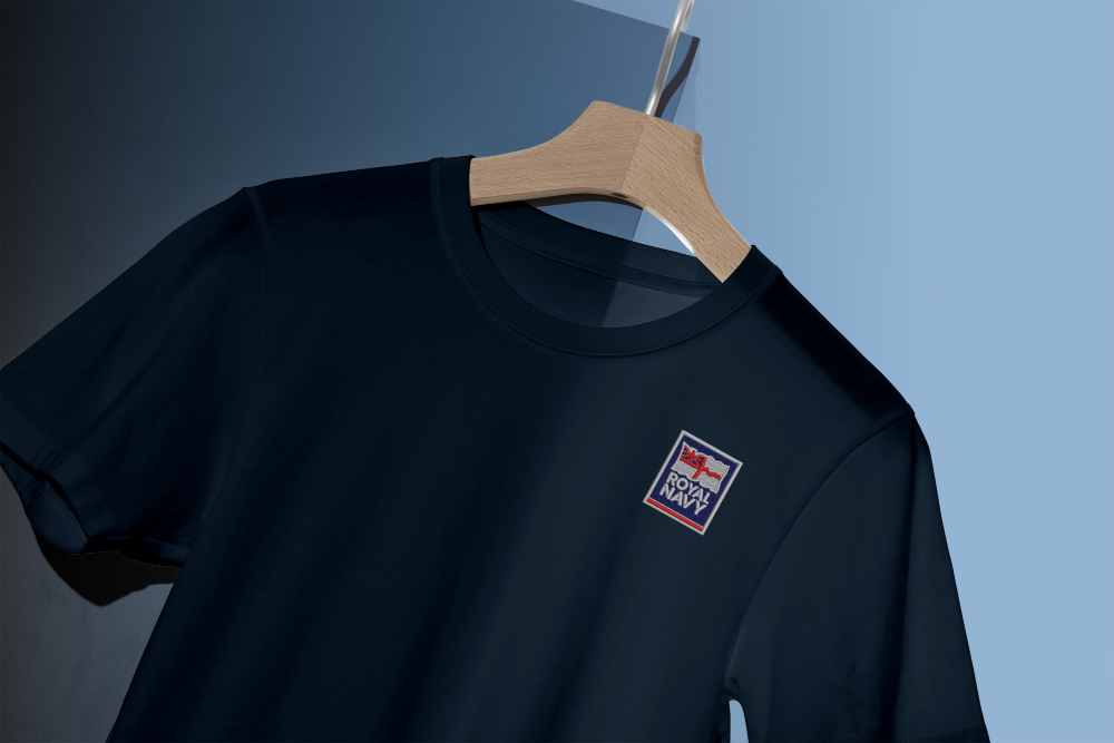 Navy blue Royal Navy T-shirt on hanger featuring embroidered Union Jack patch – British Royal Navy veterans clothing, Navy supporter T-shirt, UK military apparel.