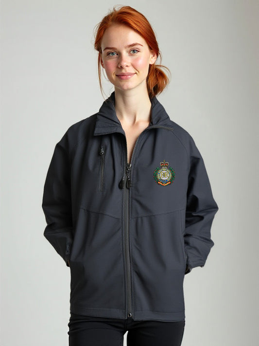 “Red-haired female model wearing a women’s Royal Engineers navy softshell jacket with stand-up collar, full-length front zipper, chest zip pocket, side hand pockets and Royal Engineers Logo embroidered on left breast.”