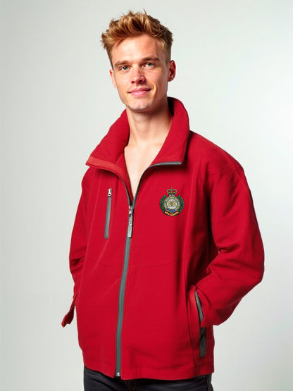 “Blond male model wearing a men’s Royal Engineers red softshell jacket with stand-up collar, full-length front zipper, chest zip pocket, side hand pockets and Royal Engineers Logo embroidered on left breast.”