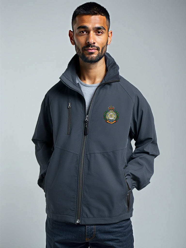 “Bearded male model wearing a men’s Royal Engineers navy softshell jacket with stand-up collar, full-length front zipper, chest zip pocket, side hand pockets and Royal Engineers Logo embroidered on left breast.”