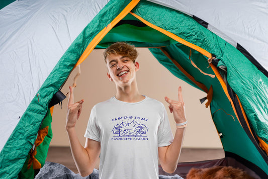  "Graphic tee with an illustration of a tent, surrounded by nature. Text reads: 'Camping is my favorite season.' Celebrate the great outdoors!"