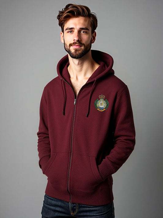 Man wearing a maroon zip-up hoodie with a Royal Engineers crest on the left chest, standing against a neutral grey background with hands in pockets.