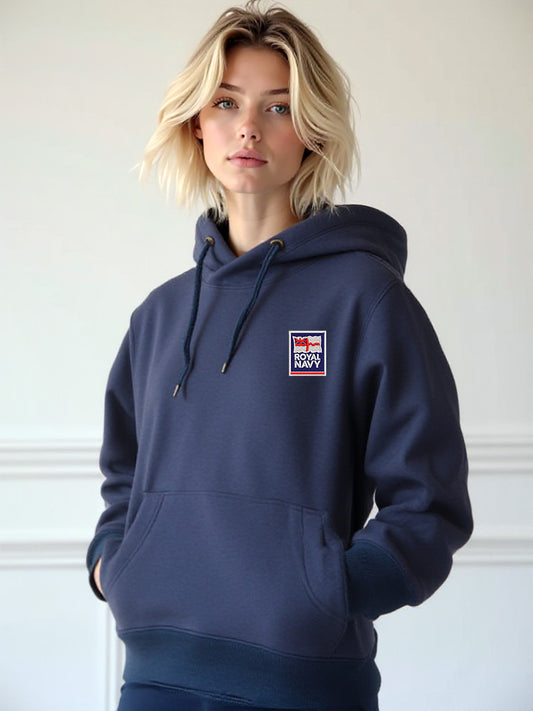 Female model wearing a navy hoodie with the Royal Navy logo embroidered on the left chest, hands in pockets, standing against a light background.

